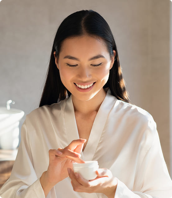 smiling young asian lady holding beauty product