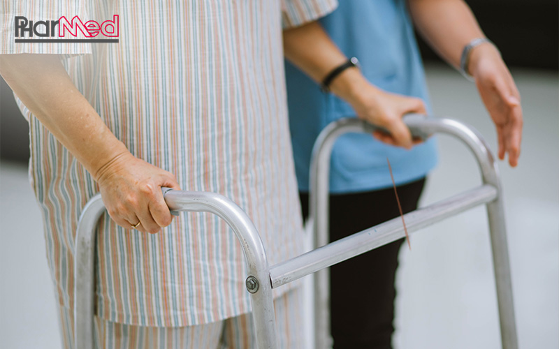 Nurse assisting an elderly patient with a walker.