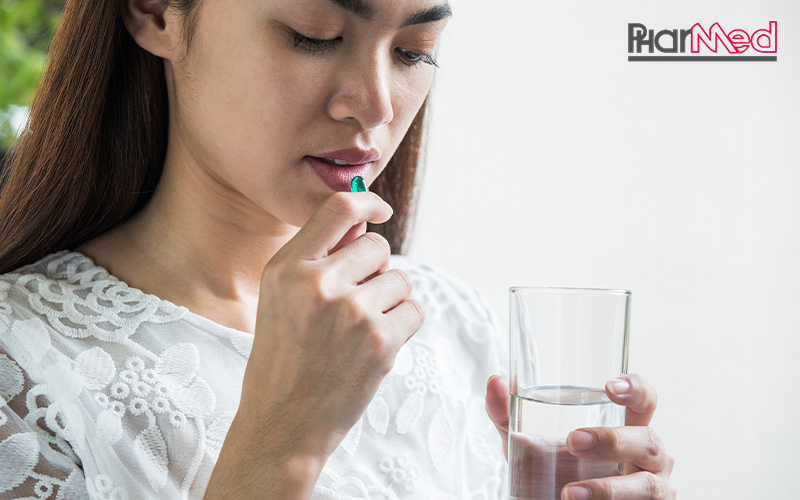 Woman taking a nutraceutical pill for preventive healthcare.