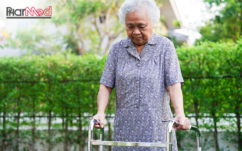 Elderly woman using a walker for mobility support.