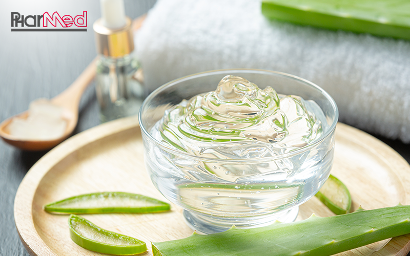 Close-up of aloe vera gel with a towel and leaves.